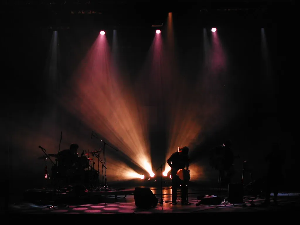 Concert sur scène sombre, faisceaux de projecteurs colorés — Cégep en spectacle, Saint-Jean-sur-Richelieu (2004).