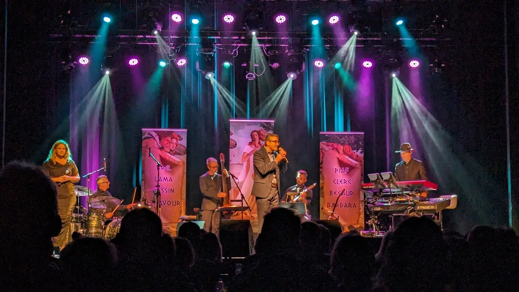 Groupe de musiciens sur scène sous un éclairage chaud et turquoise — spectacle de variété, Cabaret Théâtre du Vieux Saint-Jean, Saint-Jean-sur-Richelieu.
